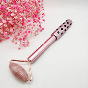 Facial massage tools on pink background