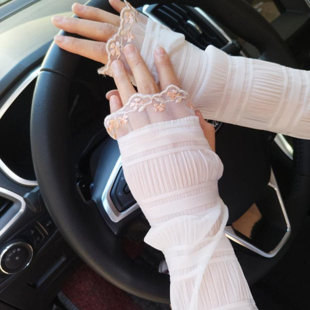 Woman wearing beige UV gloves while driving