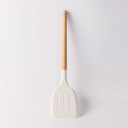 Close-up of individual white spatula with wooden handle